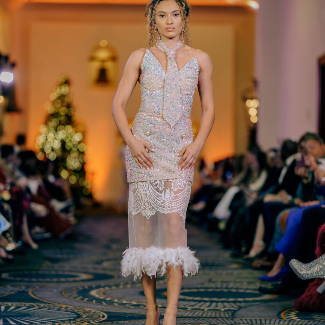 Bold Artemis haute couture short dress with bustier, tie, and feather accents.