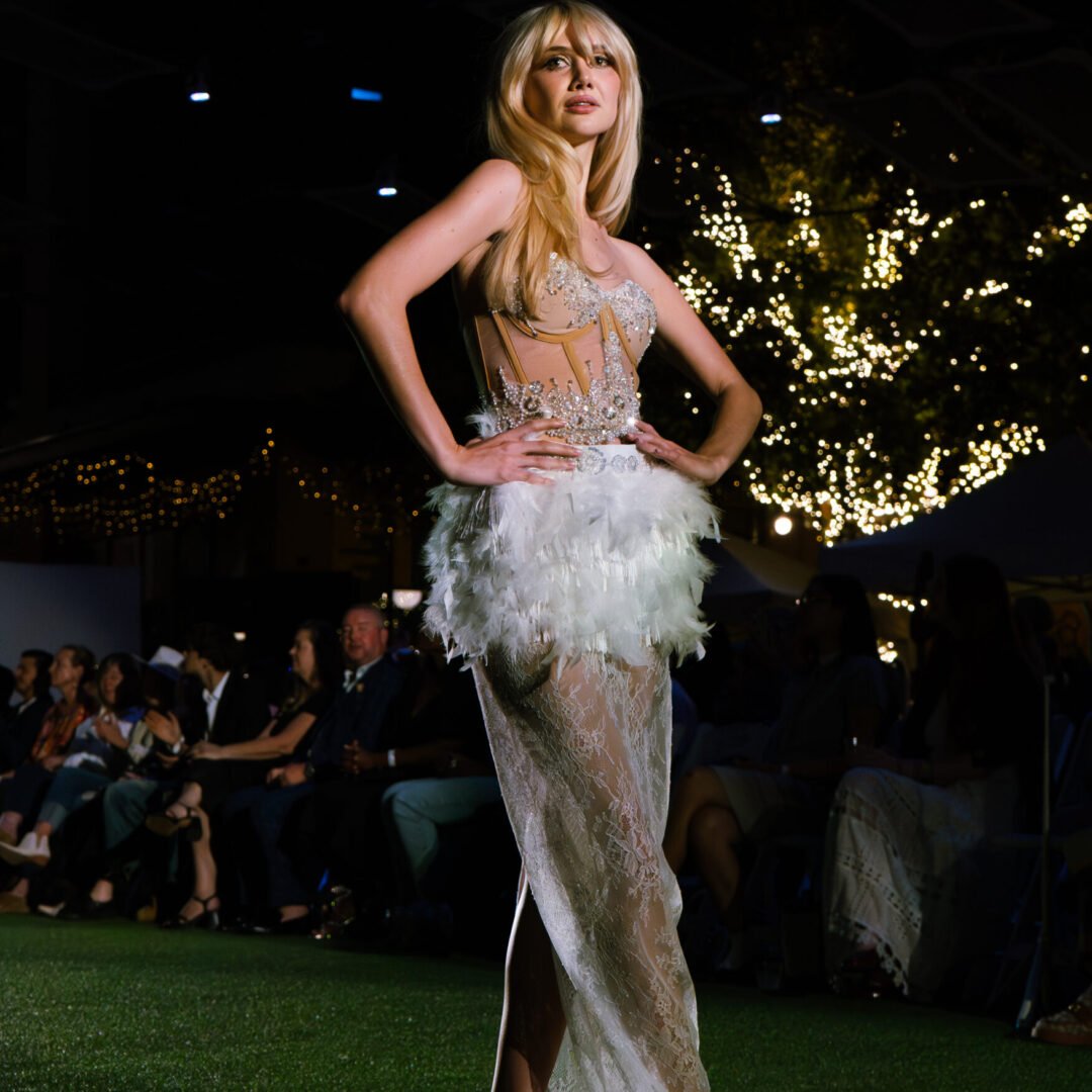 Dramatic FÉNIX haute couture gown with flowing feathers and fringes symbolizing rebirth.